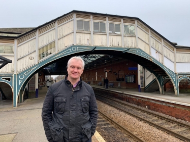 Graham stood in front of the bridge at Beverley train station