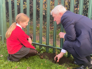 Graham planting a tree with their School Eco-Minister Angel